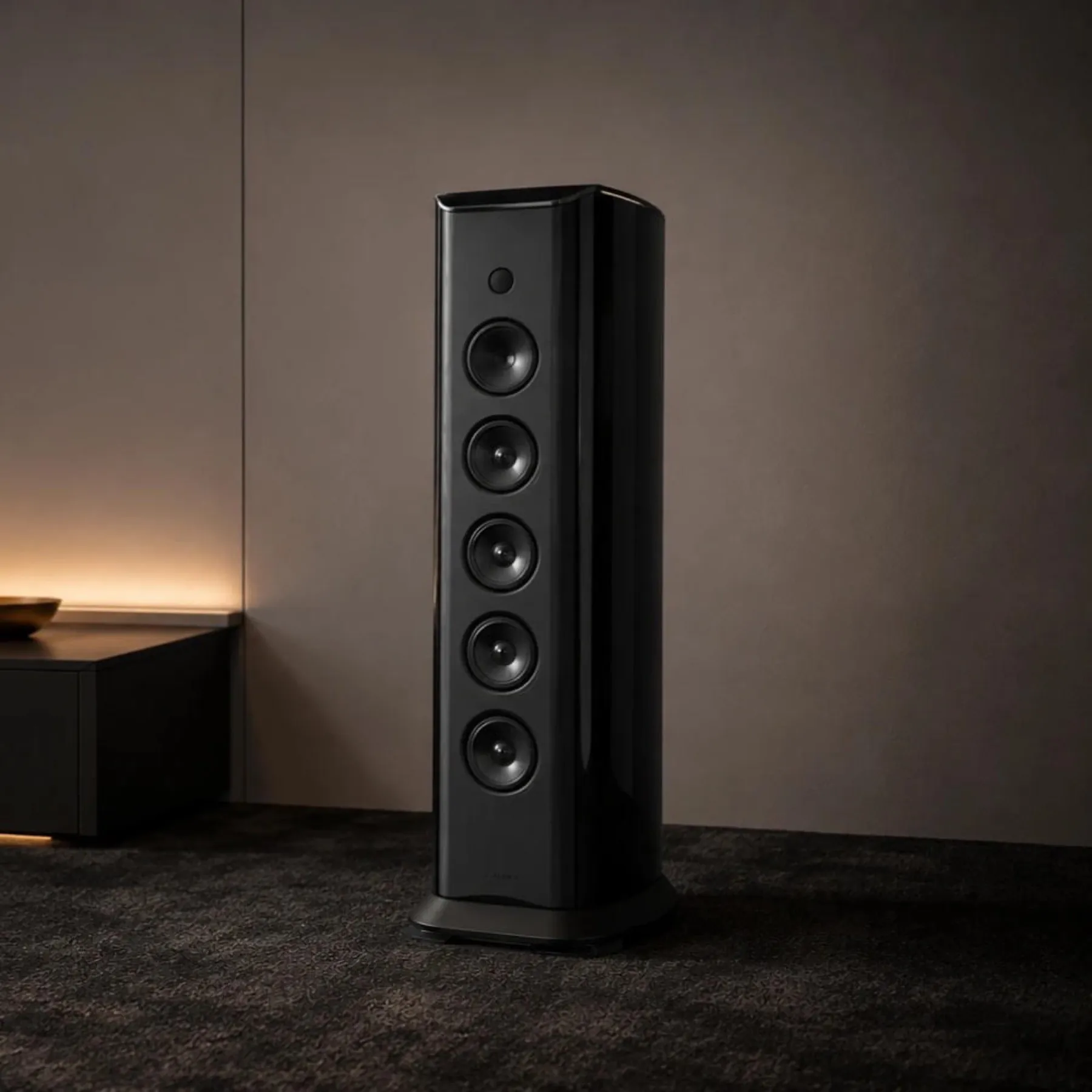 Enceinte colonne active JL Audio Primacy T6 en finition noir laqué, dans un salon.