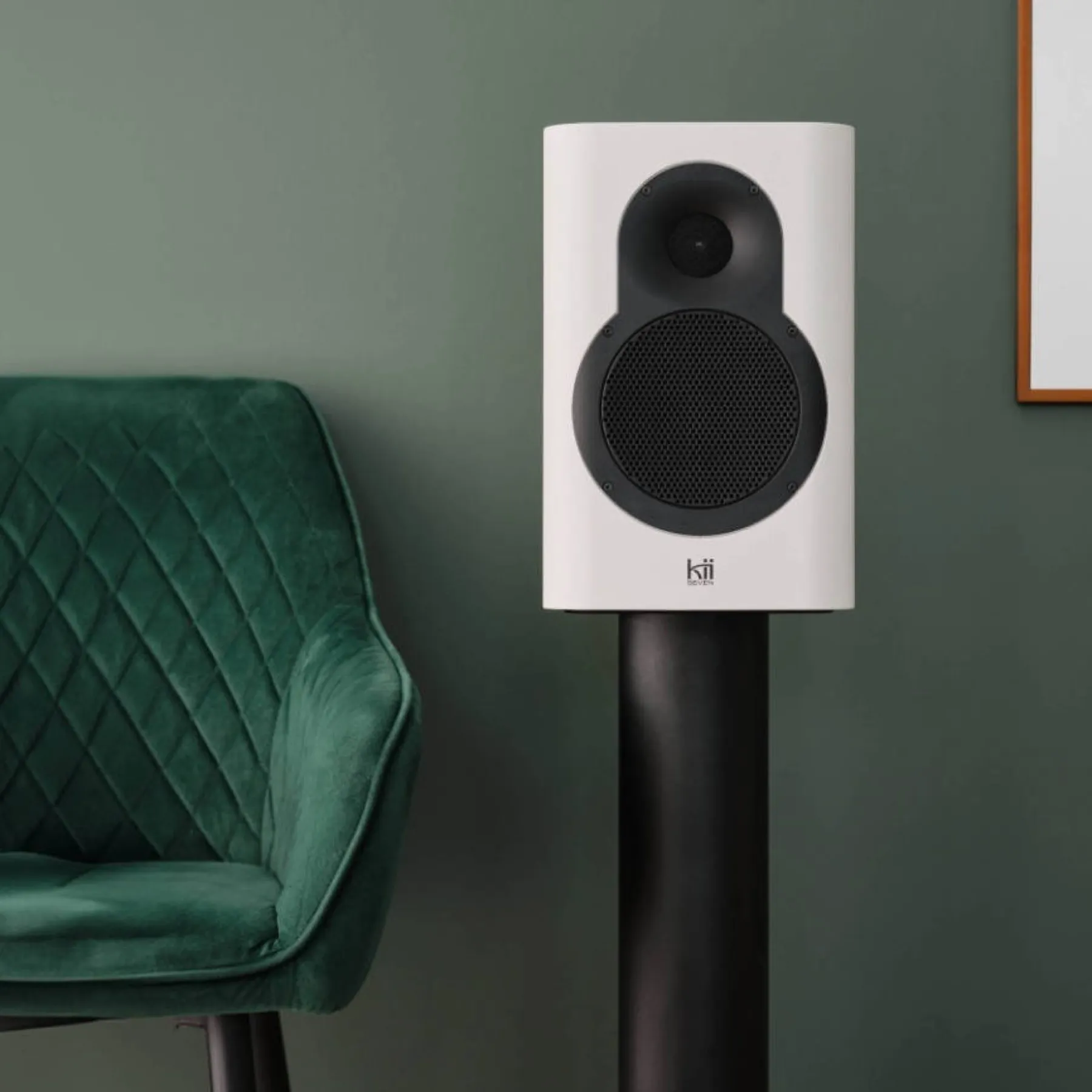 Enceinte active Kii Seven blanche sur pied, dans un intérieur.